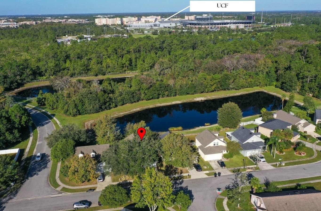 drone shot of home in area with lots of trees